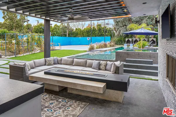 a view of a patio with a table chairs and a fire pit