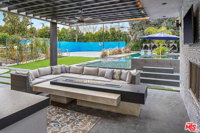 a view of a patio with a table chairs and a fire pit
