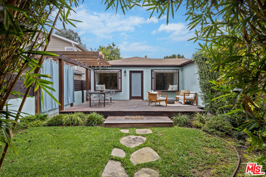 a view of a patio with table and chairs potted plants and palm tree