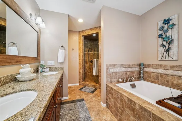 a bathroom with a granite countertop tub a sink and a bath tub