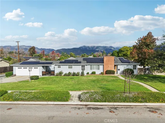 a view of a house with a big yard and large trees