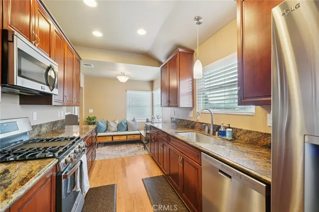 a kitchen with stainless steel appliances granite countertop a stove a sink and a microwave
