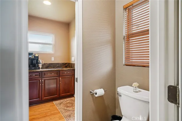 a bathroom with a granite countertop sink and a toilet