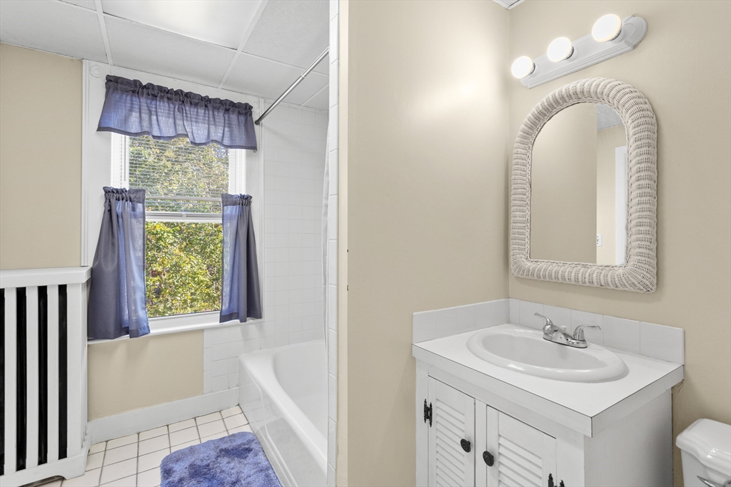 6 Barker Street Methuen, MA 01844 - Photo 28 of 42 a bathroom with a sink a mirror a vanity and a bathtub