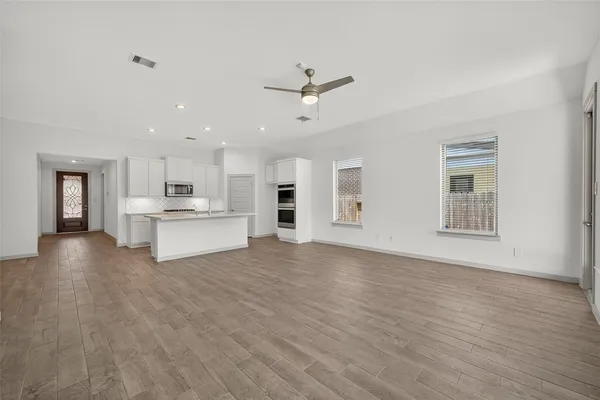 a view of kitchen with wooden floor and electronic appliances