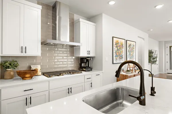 a kitchen with a sink white cabinets and appliances