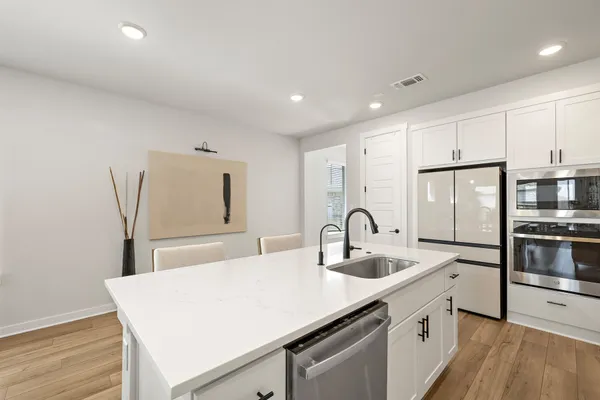 a kitchen with stainless steel appliances granite countertop a sink stove and refrigerator