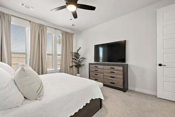 a bedroom with a large bed and a tv on a dresser