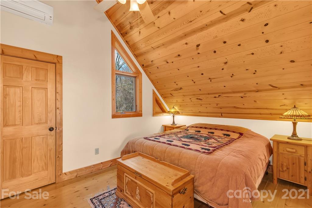 2794 Utah Mountain Road Waynesville, NC 28785 - Photo 19 of 27 a bedroom with a bed and a wooden floor