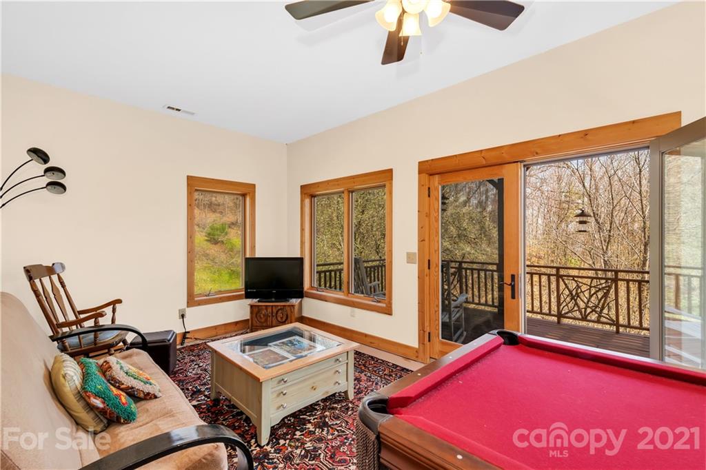 2794 Utah Mountain Road Waynesville, NC 28785 - Photo 23 of 27 a living room with furniture a flat screen tv and a window