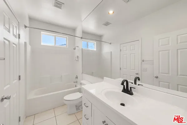 a kitchen with a refrigerator a stove top oven and white cabinets