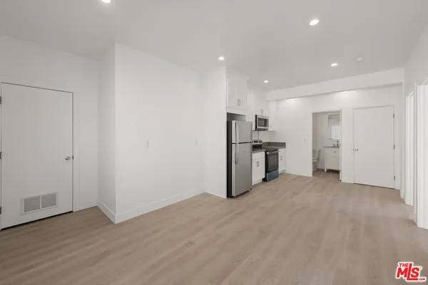 a view of a kitchen with a sink and a refrigerator