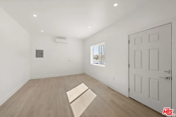 an empty room with a ceiling fan and bathroom view
