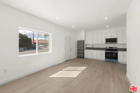 an empty room with a window and ceiling fan