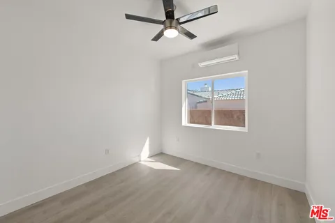 an empty room with a ceiling fan and bathroom view
