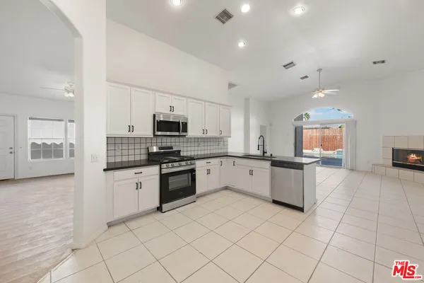a large white kitchen with cabinets