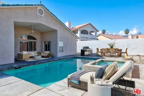a view of a house with swimming pool and furniture