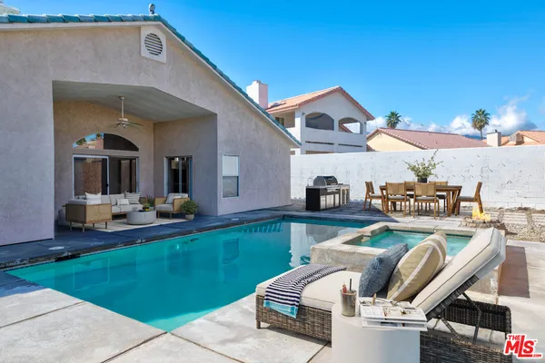 a view of a house with swimming pool and furniture