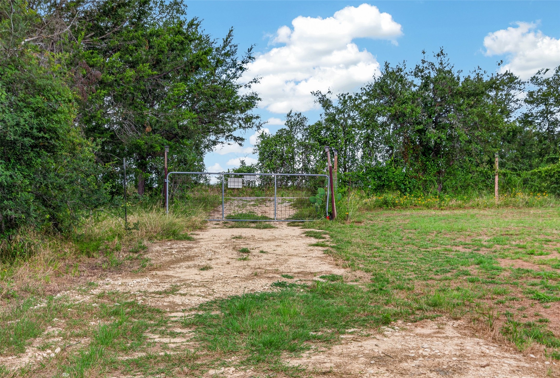 266 Beaver Road Elgin, TX 78621 - Photo 36 of 40 Secure gated entry to a private, undeveloped parcel with natural landscaping.