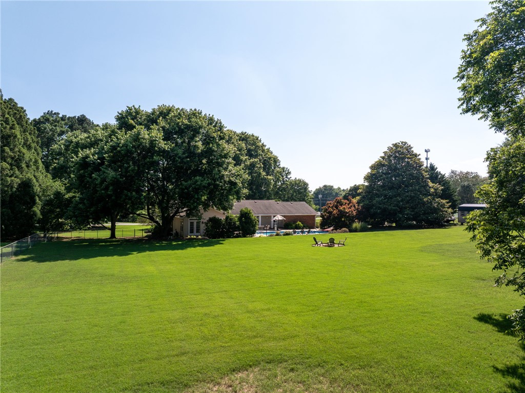 3513 Hopewell Road Anderson, SC 29621 - Photo 41 of 50 A sprawling green lawn offers ample space for recreation, complemented by a private pool and mature shade trees.