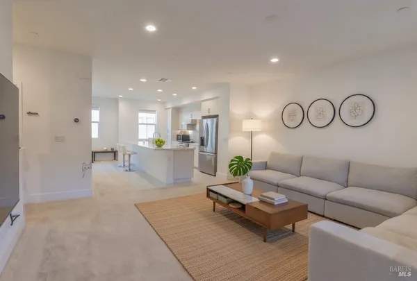 a living room with furniture kitchen view and a table