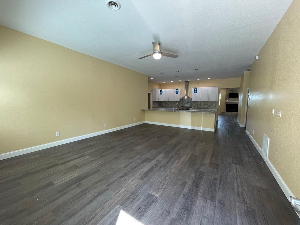 1763 Rays Gap Road Seymour, TN 37865 - Photo 9 of 34 an empty room with wooden floor kitchen view and a chandelier