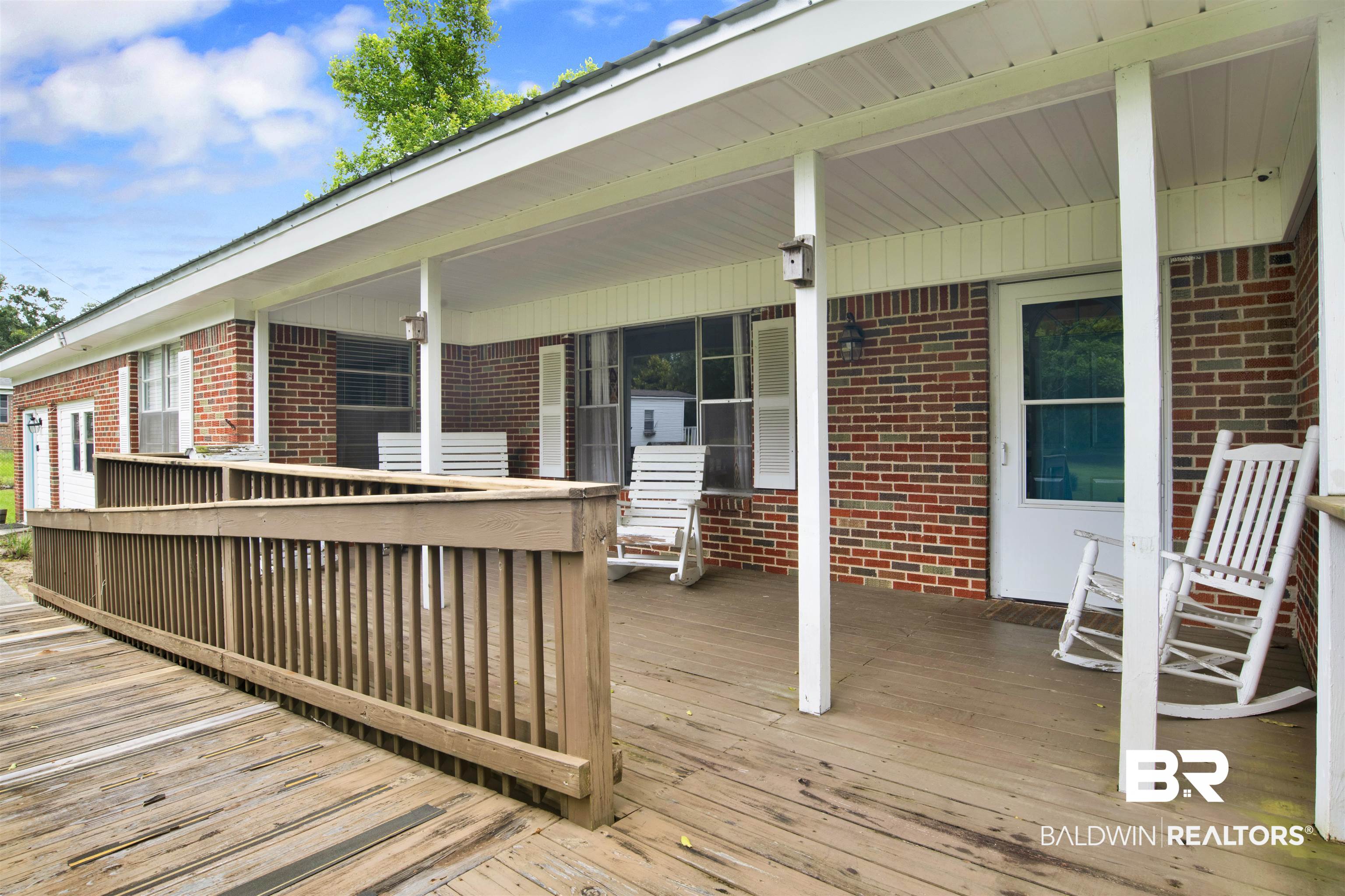 17714 Horseneck Road Bay Minette, AL 36507 - Photo 2 of 36 Brick exterior with a covered porch featuring a wood-finish floor and white support columns