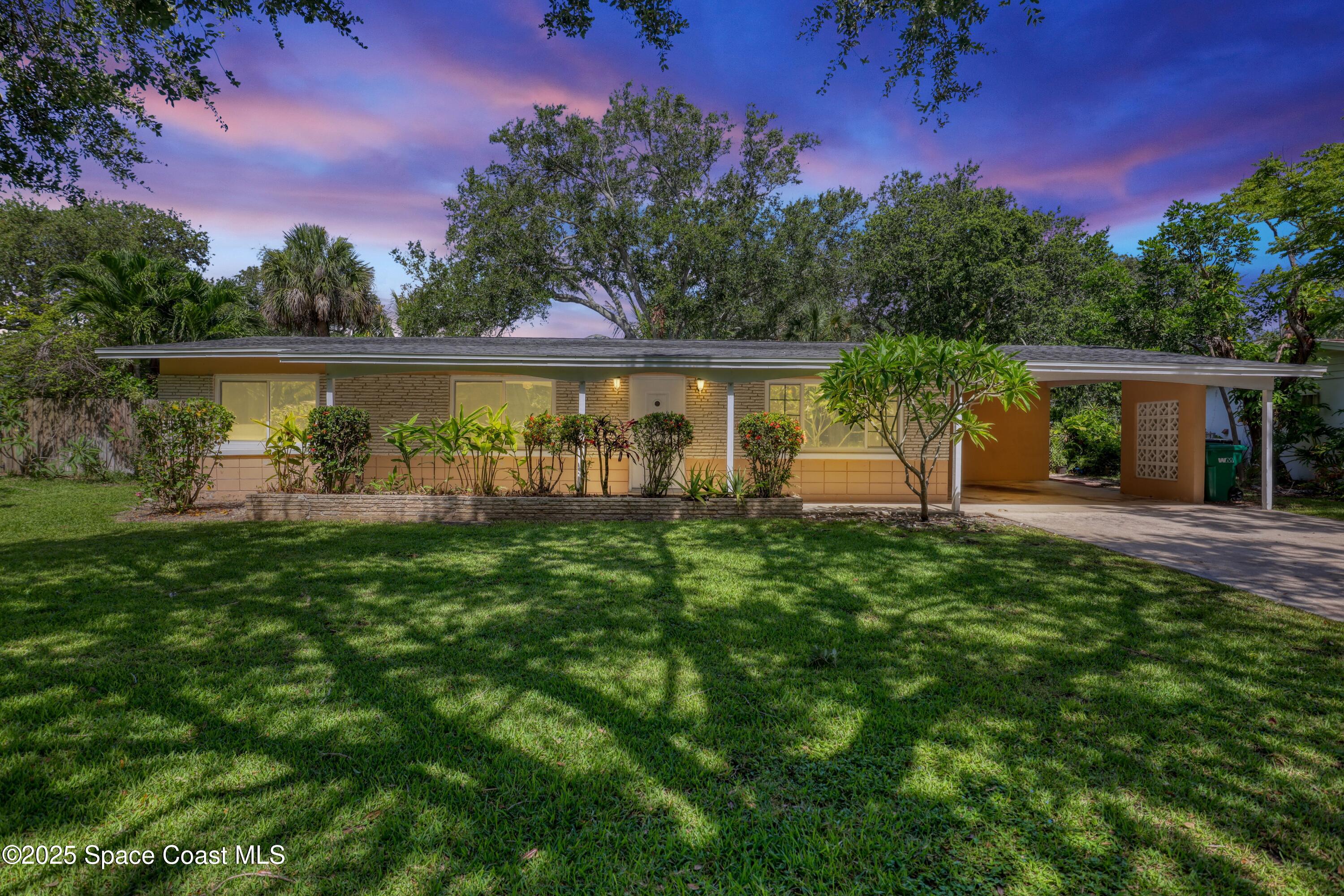 955 Samar Road Cocoa Beach, FL 32931 - Photo 1 of 37 a view of a house with a yard and a tree