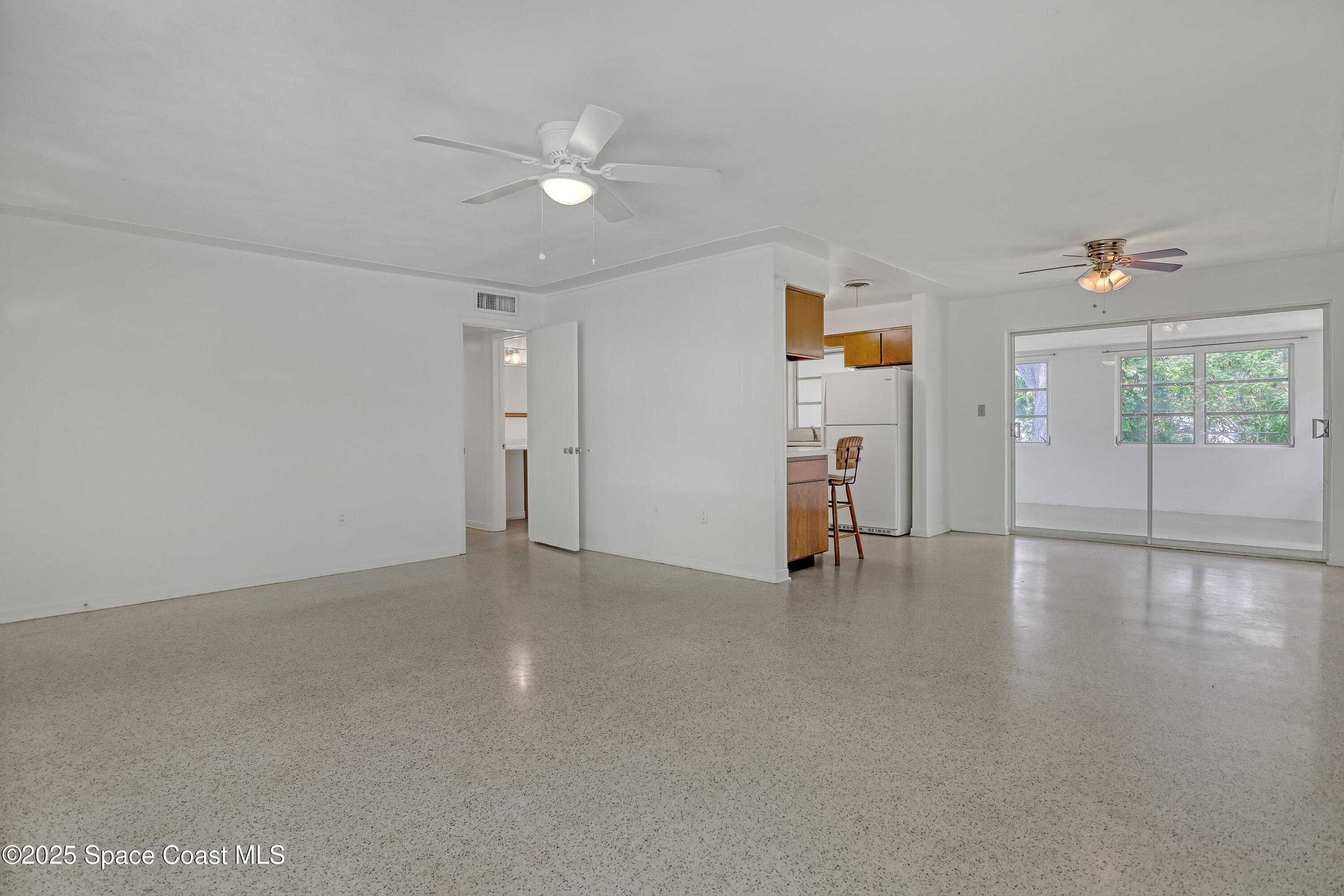 955 Samar Road Cocoa Beach, FL 32931 - Photo 11 of 37 a view of empty room with wooden floor and fan