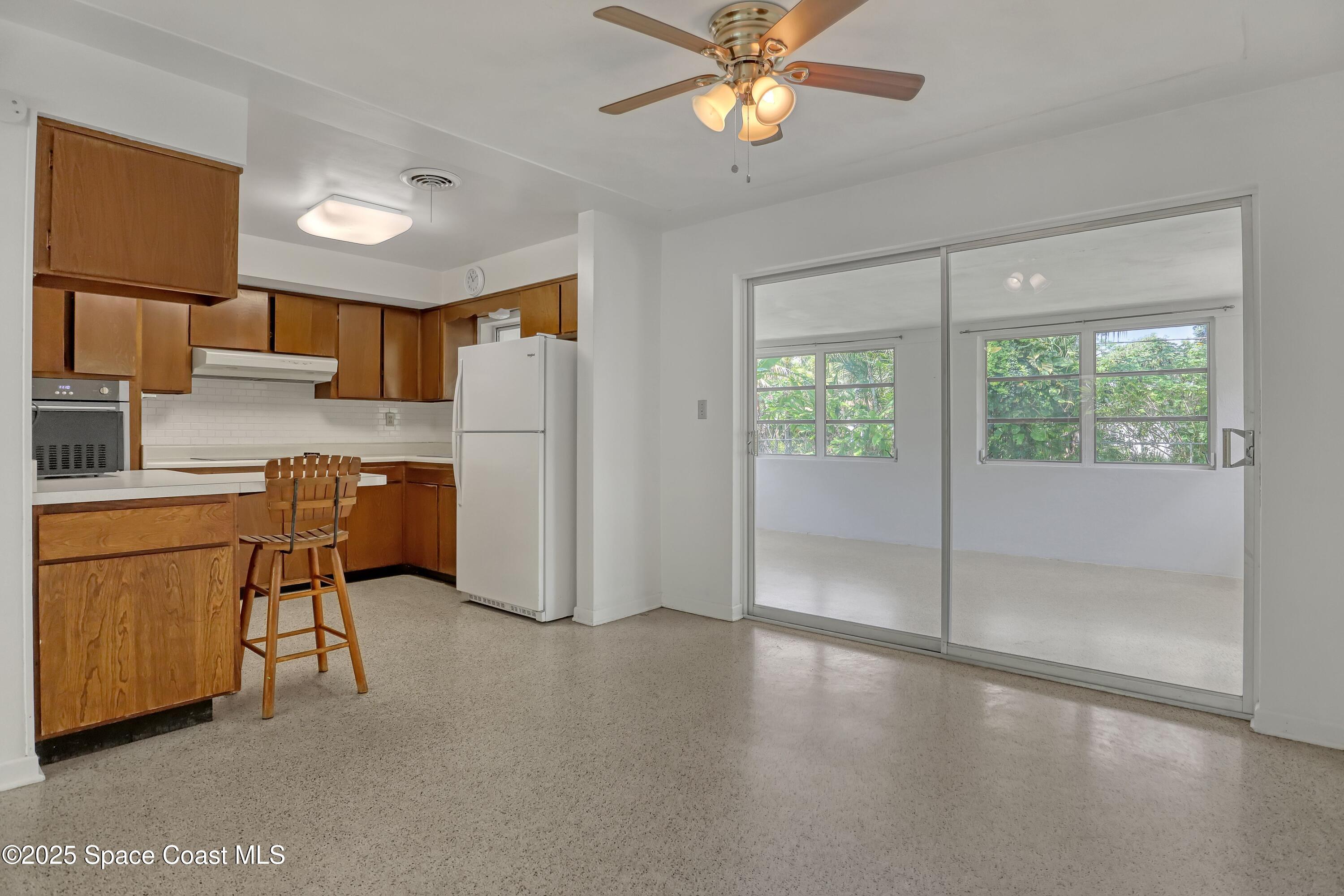 955 Samar Road Cocoa Beach, FL 32931 - Photo 13 of 37 a kitchen with stainless steel appliances granite countertop a refrigerator a sink a stove top oven a counter space and cabinets