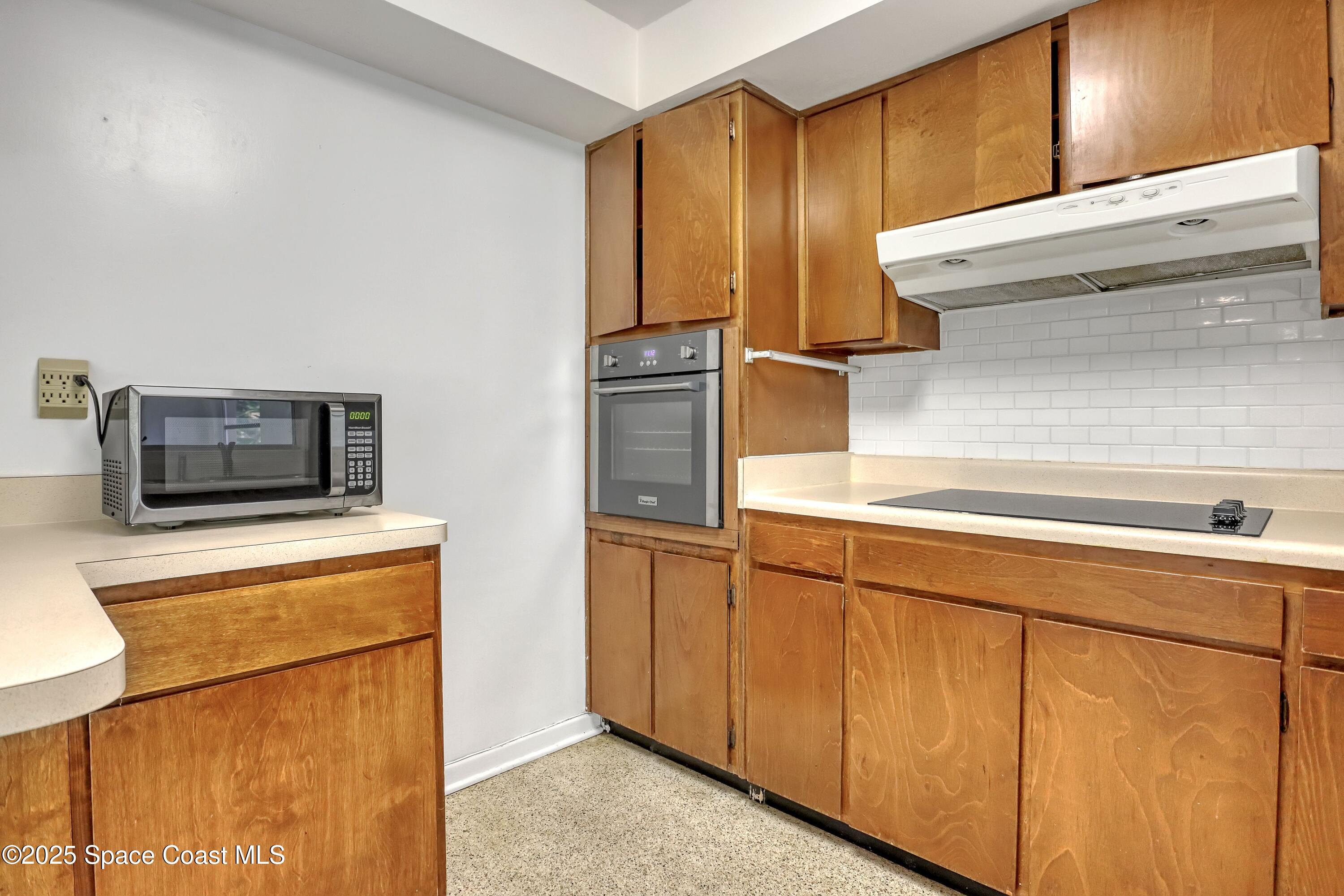 955 Samar Road Cocoa Beach, FL 32931 - Photo 21 of 37 a kitchen with stainless steel appliances granite countertop cabinets and a refrigerator