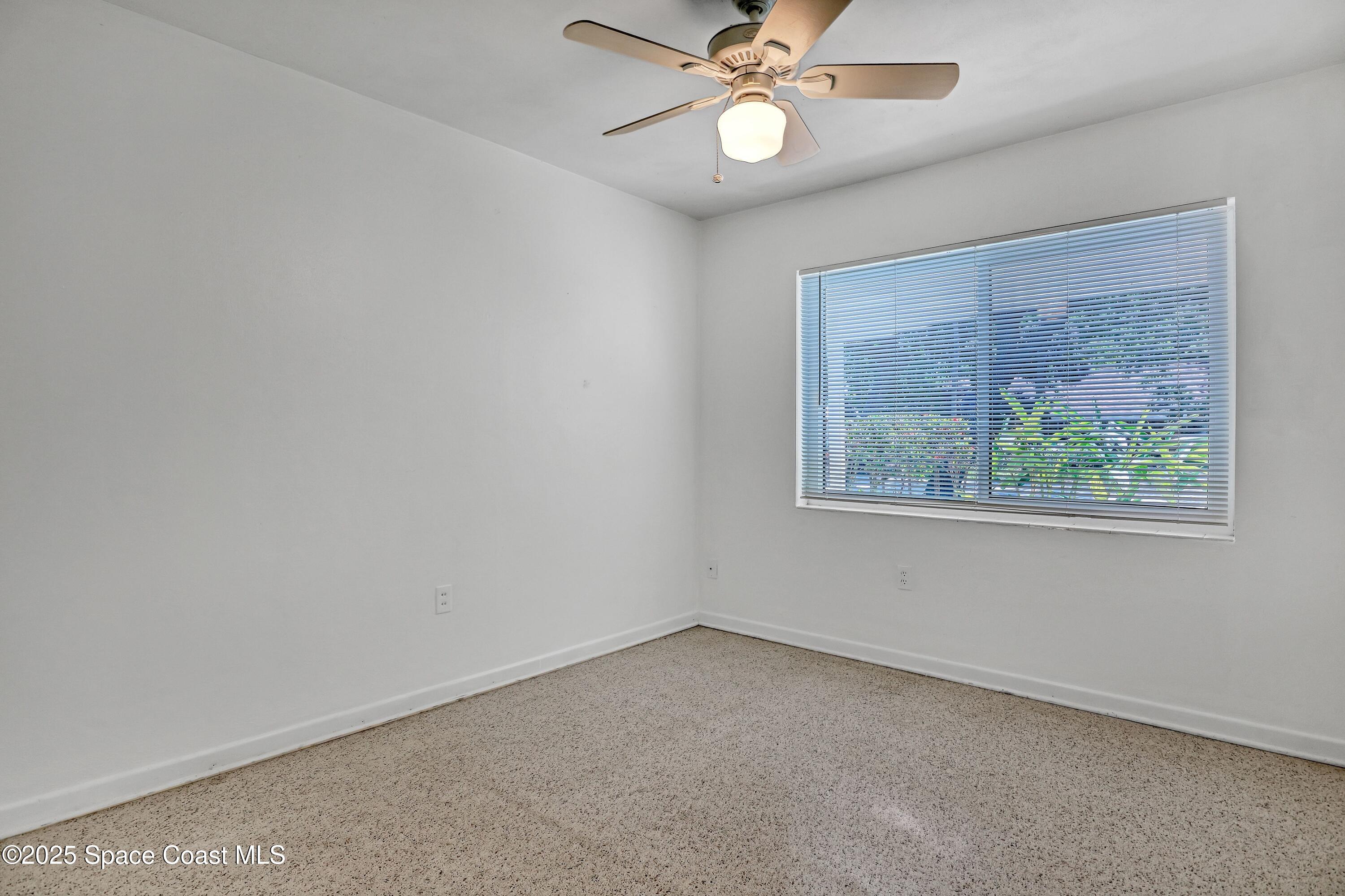 955 Samar Road Cocoa Beach, FL 32931 - Photo 28 of 37 an empty room with a window and a fan