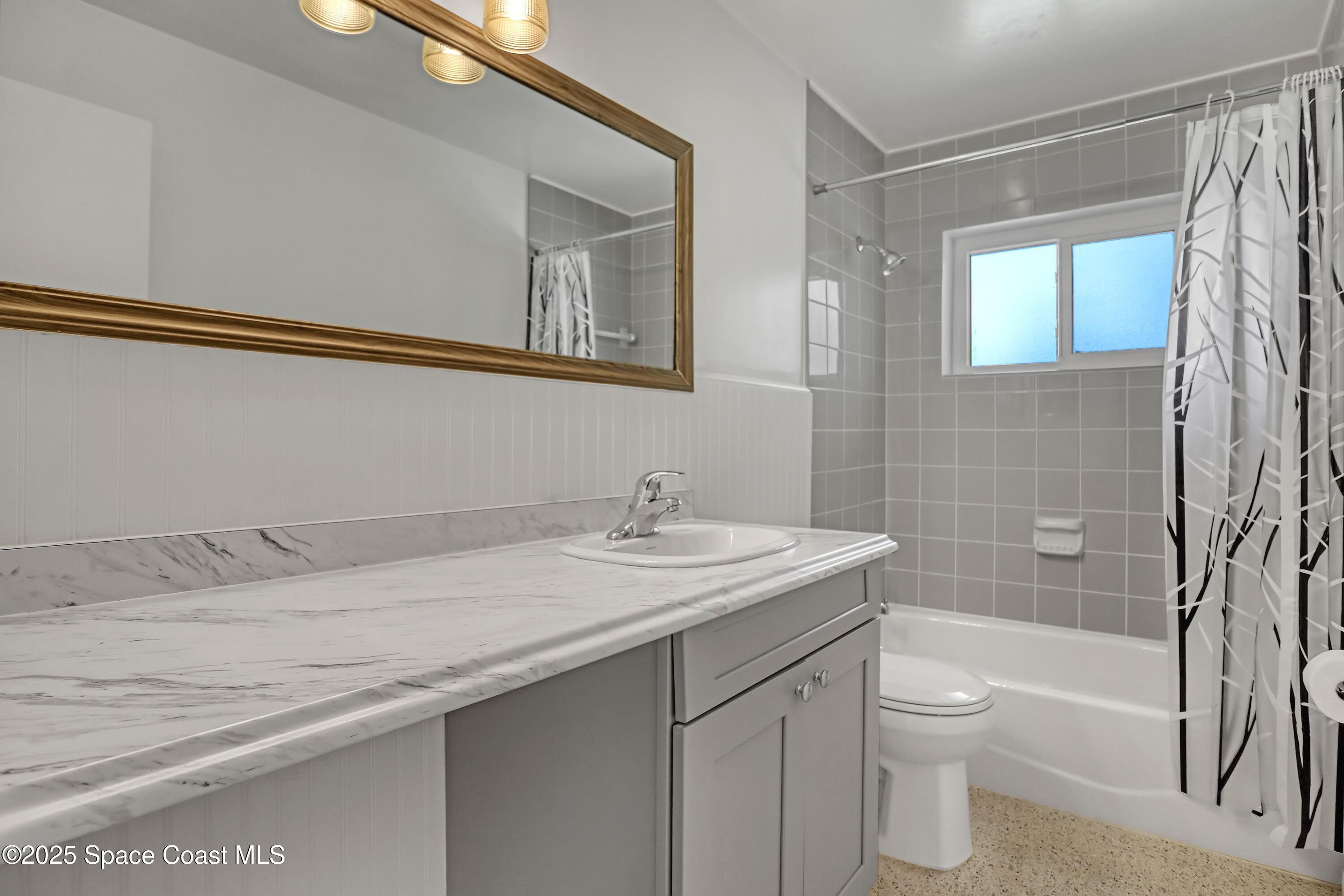955 Samar Road Cocoa Beach, FL 32931 - Photo 29 of 37 a bathroom with a granite countertop sink a toilet and shower