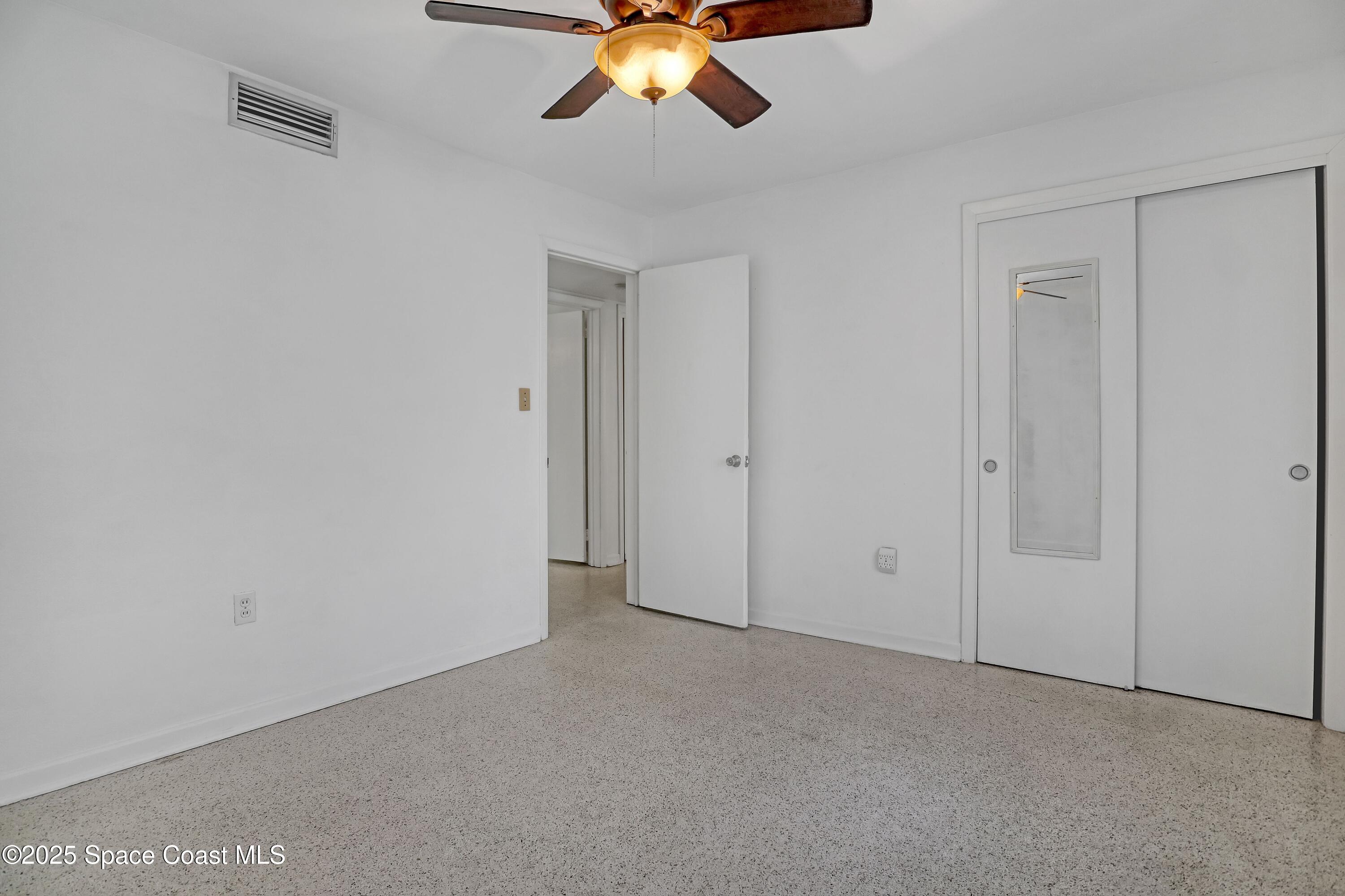 955 Samar Road Cocoa Beach, FL 32931 - Photo 30 of 37 an empty room with a chandelier fan