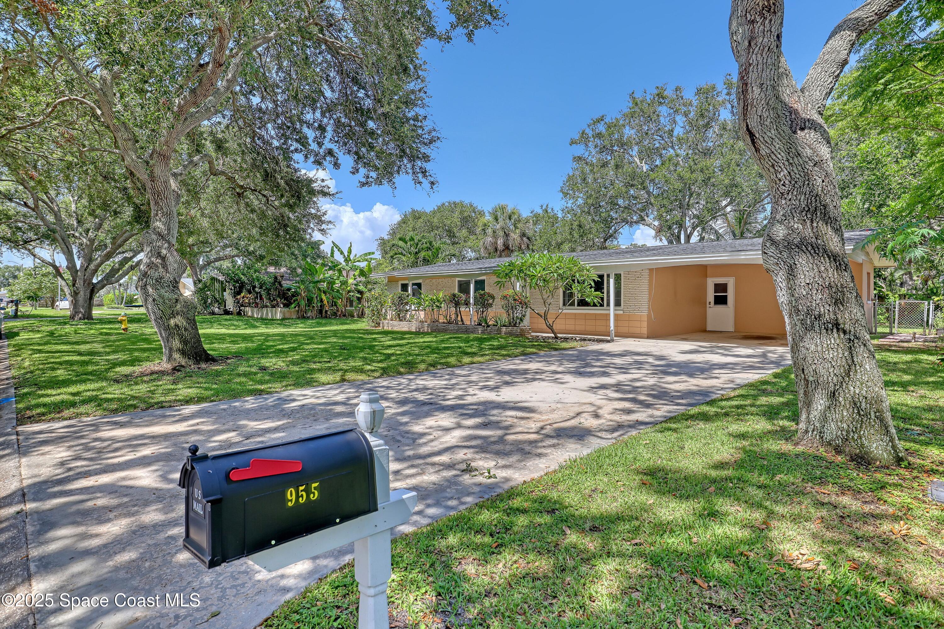 955 Samar Road Cocoa Beach, FL 32931 - Photo 3 of 37 a front view of a house with a garden