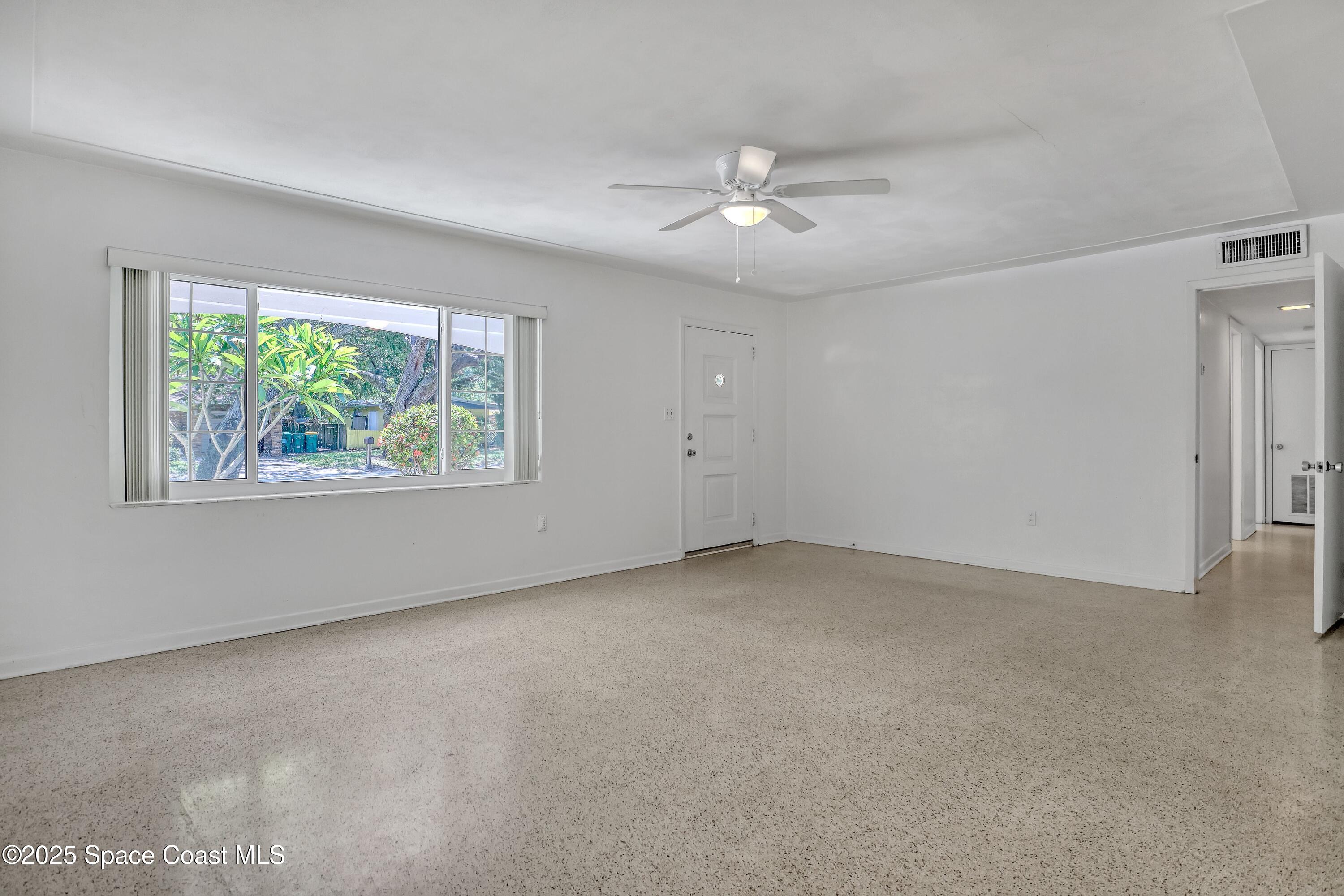 955 Samar Road Cocoa Beach, FL 32931 - Photo 9 of 37 an empty room with windows and ceiling fan