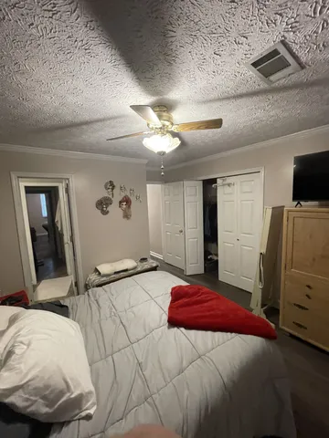 a bedroom with a bed and a flat tv screen on a dresser