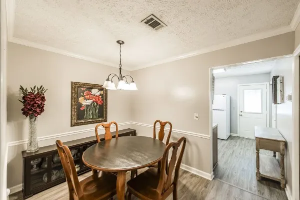 a view of a dining room with furniture wooden floor and a chandelier