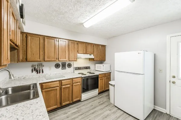 a kitchen with a sink a refrigerator a stove and cabinets