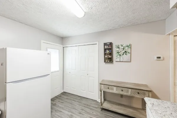 a view of kitchen with a refrigerator a stove a microwave and white cabinets