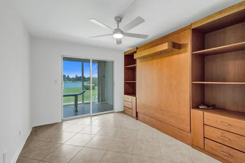 a view of an empty room with closet and a window