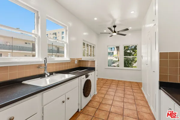 a kitchen with a stove a sink a dining table and chairs
