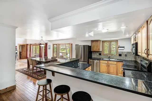 a kitchen with stainless steel appliances granite countertop a sink stove and cabinets