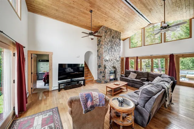 a living room with furniture a flat screen tv and a floor to ceiling window