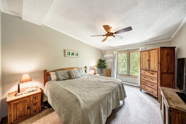 a bedroom with a bed and a refrigerator