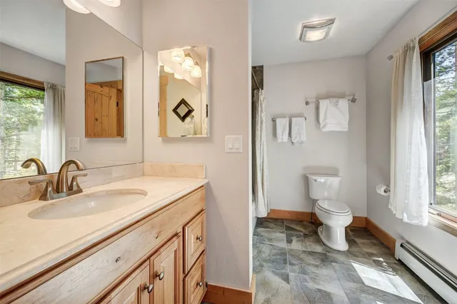 a bathroom with a sink a toilet and a mirror