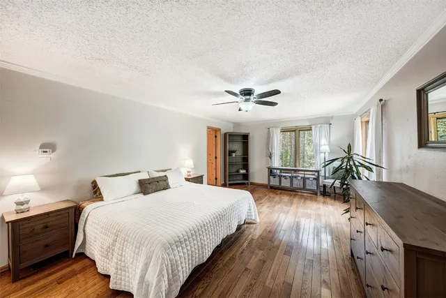 a spacious bedroom with a bed and wooden floor