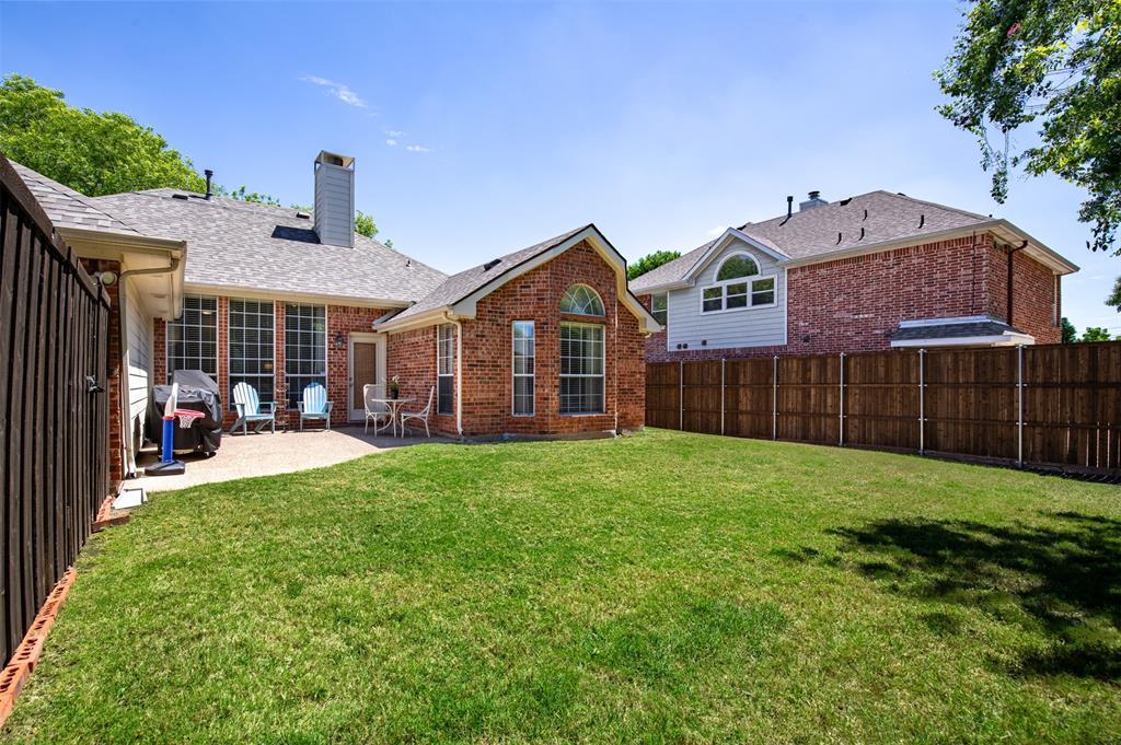6425 Radslow Drive Frisco, TX 75035 - Photo 31 of 34 Back of property featuring grassy yard and wood privacy fence.