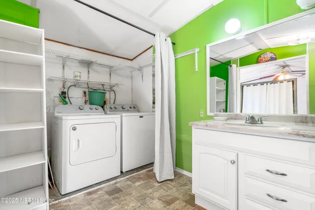 a bathroom with a granite countertop sink mirror vanity and next to a window