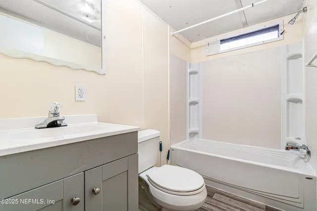 a bathroom with a sink a toilet a mirror and shower